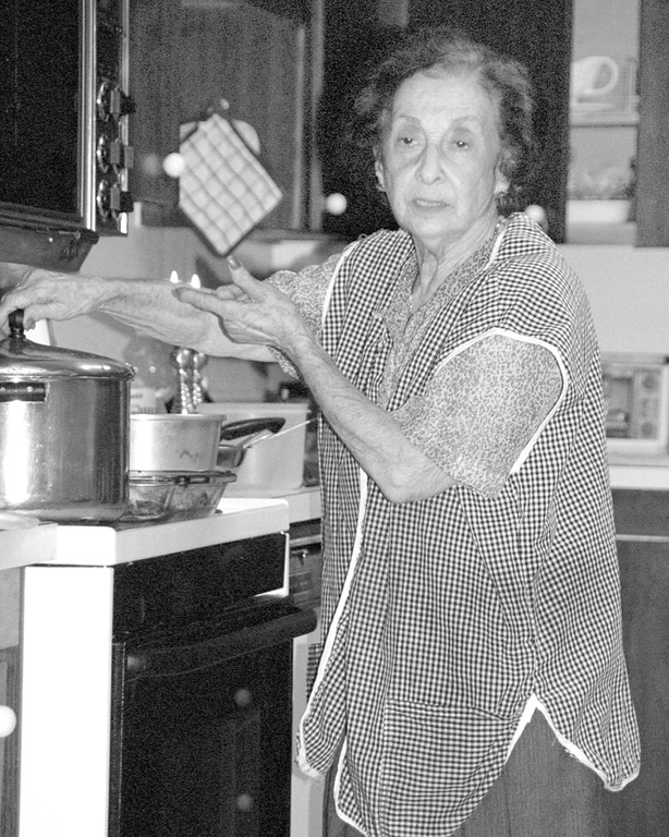 Mary Tamres at her stove in a gingham apron, 2005